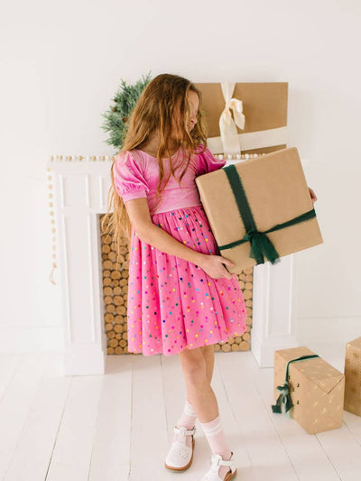 Little girl modeling the pink velvet dress showing you the dress hits at the knee