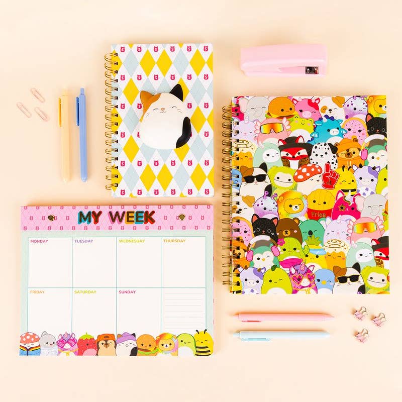 Set of stationery items including a planner, stickers, and pens on a beige background