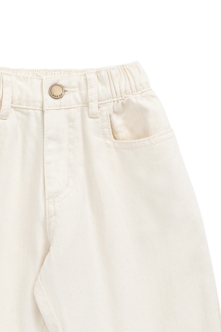 Close-up of beige pants with a button on a white background