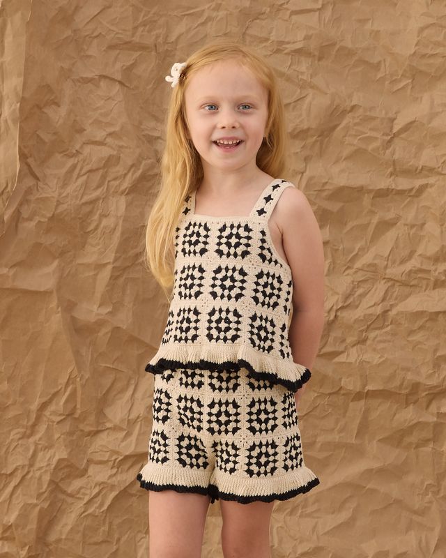 girl wearing the black and beige crochet set with ruffle details 