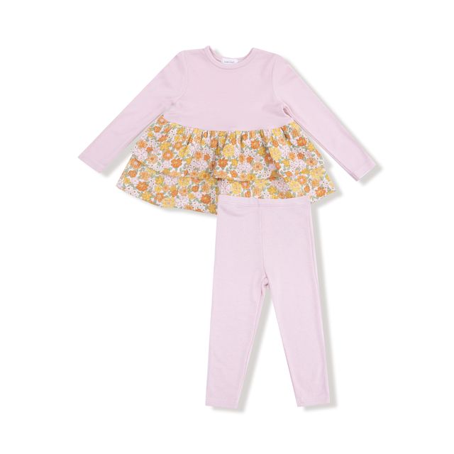 Children's outfit with pink top and pants and floral skirt on a white background