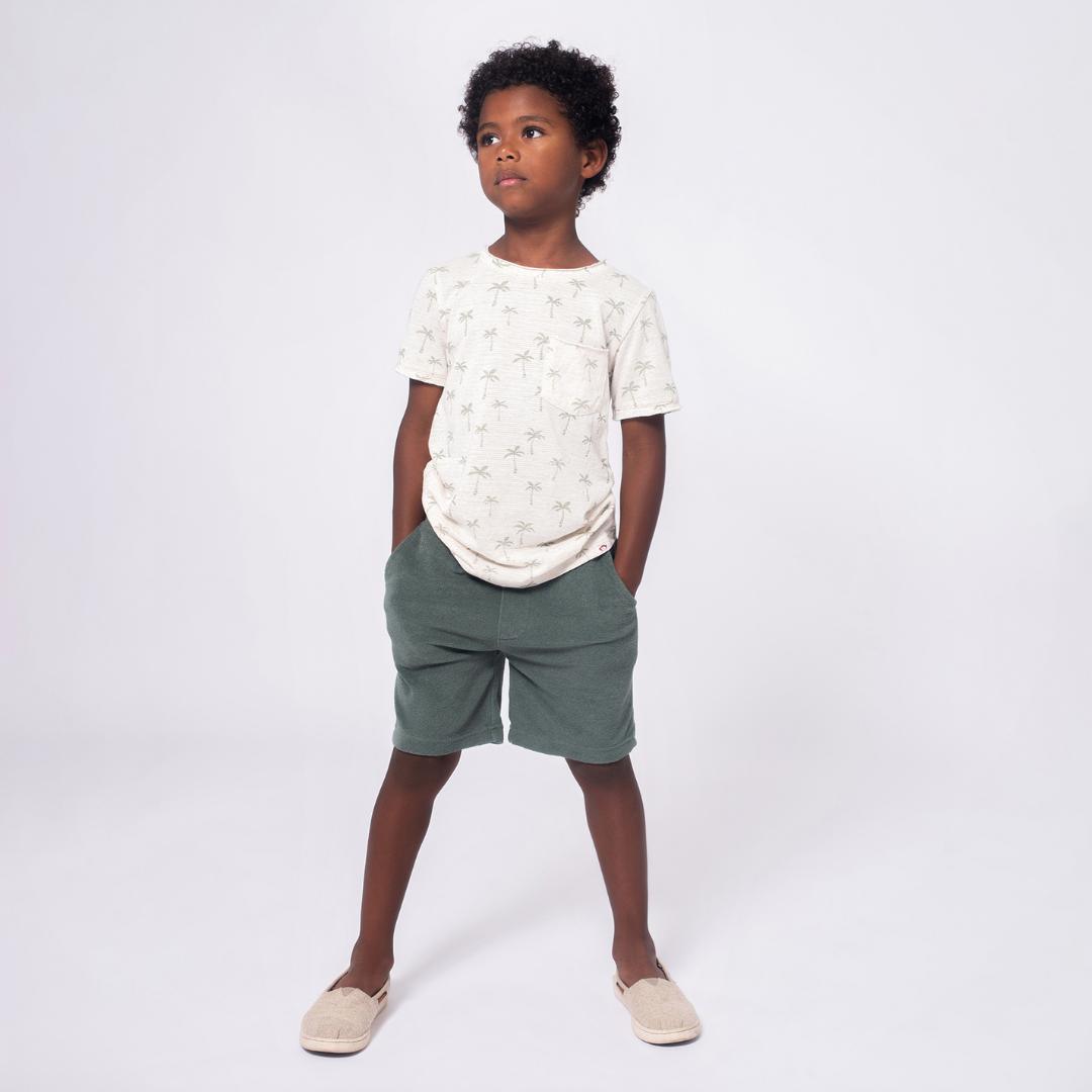 young boy modeling the palm tree tee and dark gray shorts. 