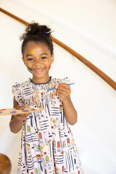 Picture of a little girl modeling the stevie dress. she is holding a painter's palette, getting ready to paint!