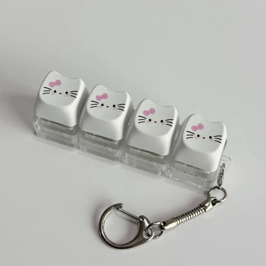 Keychain with cat-shaped keycaps on a gray background