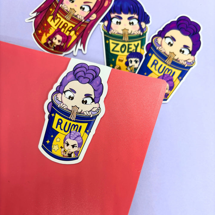 Bookmarks  with cartoon characters in cups labeled 'Rumi', 'Zoe', and 'Mira' on a red and purple background.