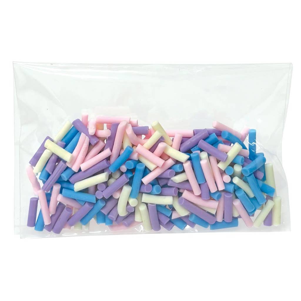 Bag of pastel-colored candy sticks on a white background