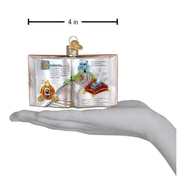 Decorative book ornament with fairy tale design, held in a hand for scale.