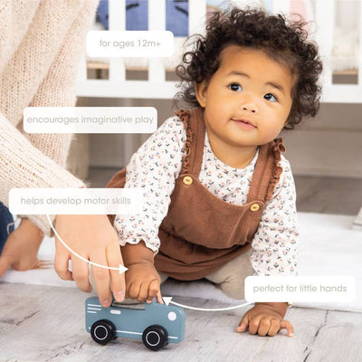 small toddler playing with the car and holding the top