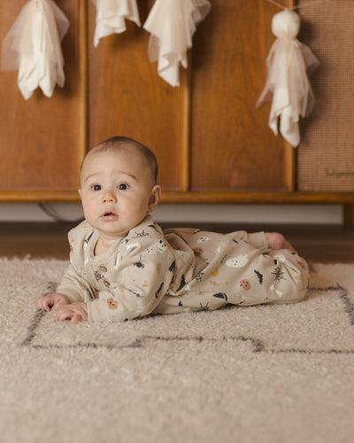 baby modeling the halloween jumpsuit. he is laying down and looking comfy