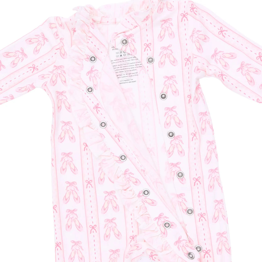 A light pink long-sleeve baby romper or sleep sack with a repeating ballet dancer silhouette pattern, featuring a double-breasted snap-button closure and a ruffled collar.