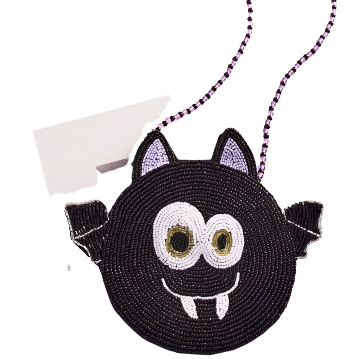 close up of the bat bag and the silly face he is making. the bat has big eyes and grinning. the color of the bag is black. 