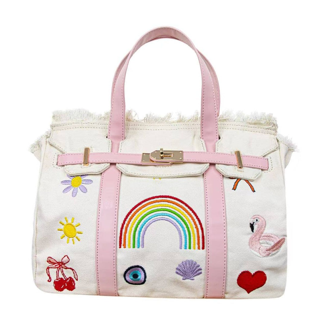 White handbag with pink accents and various embroidered designs on a white background