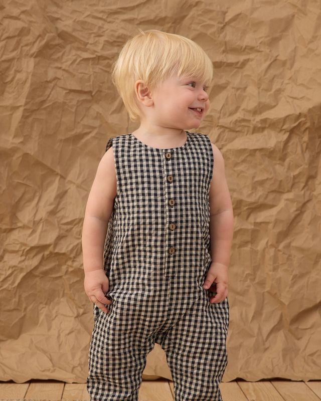 baby boy wearing a black and white gingham sleeveless romper 