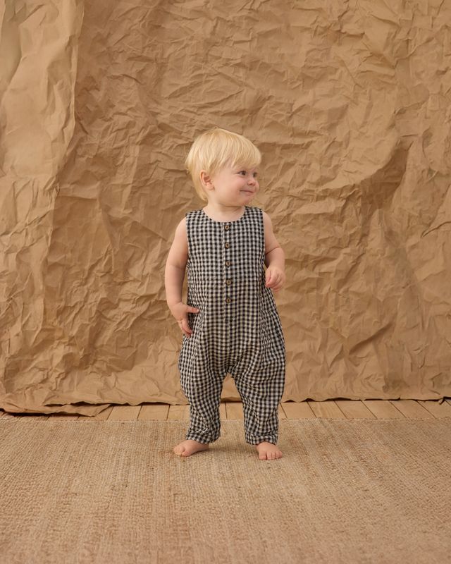 baby boy wearing a black and white gingham romper. 