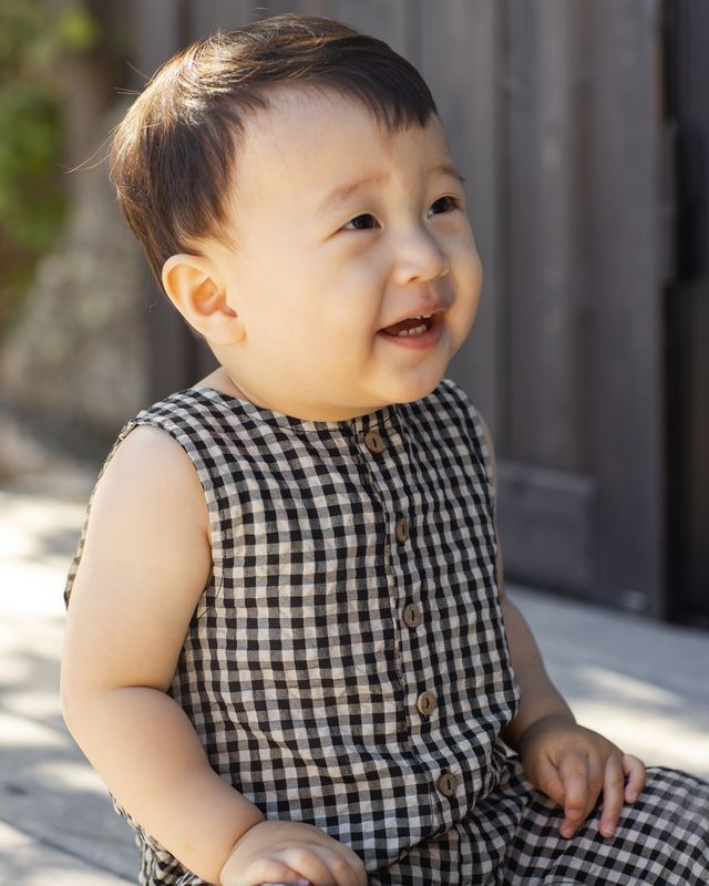 baby wearing a black and white gingham romper 