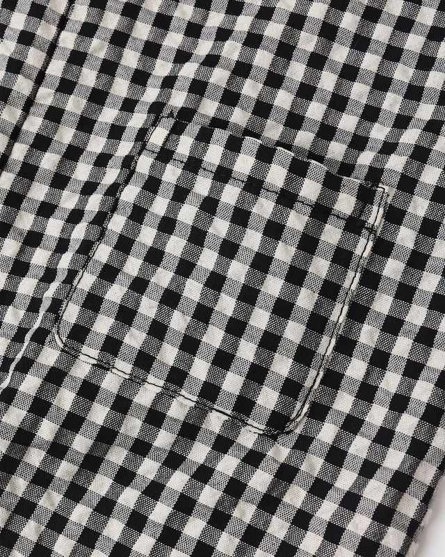 Close-up of a black and white checkered fabric with a pocket detail.