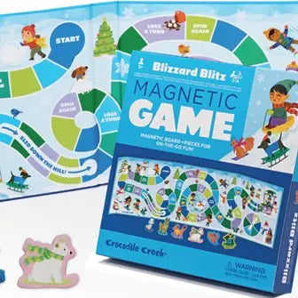Blizzard Blitz Magnetic Game by Crocodile Creek, showing the blue game box in front of the circular magnetic board game with colorful illustrated pieces and a small wooden snowman piece on a white background.