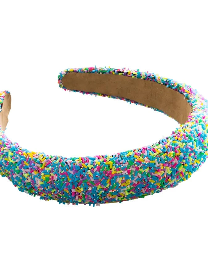 Multi colored sprinkles cover a chunky girls headband, blue being a dominant color