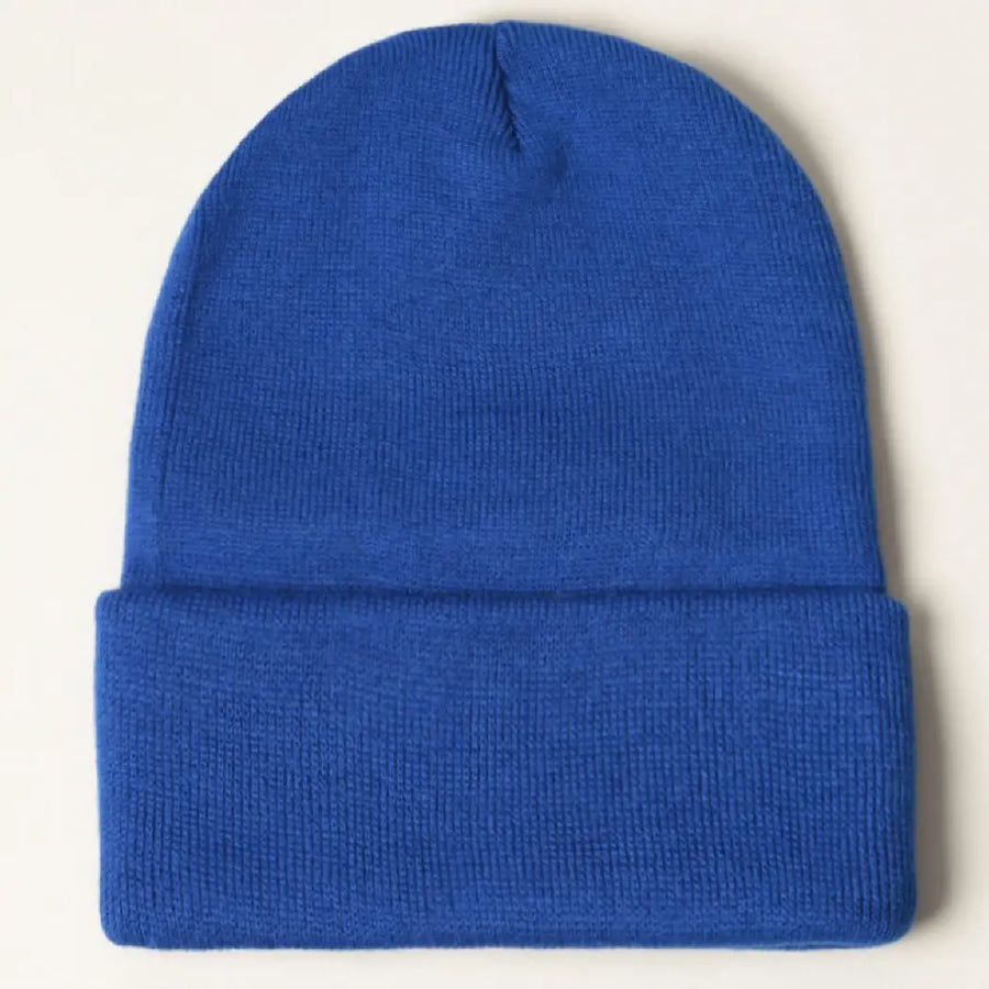 A solid royal blue knit beanie hat with a folded cuff, shown flat against a light off-white background.