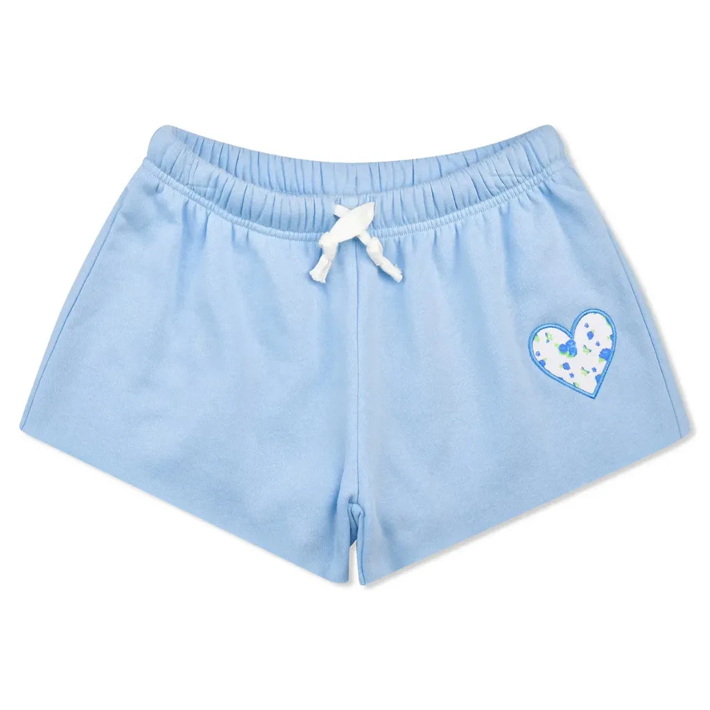 Light blue sweat shorts with a white drawstring and a blue and white patterned heart on the left leg, shown against a plain white background.