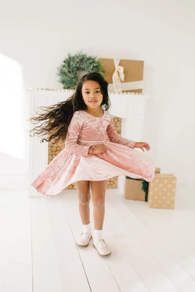 Little girl modeling the dress and twirling in it.  Her skirt has a big twirl on it as she spins. 