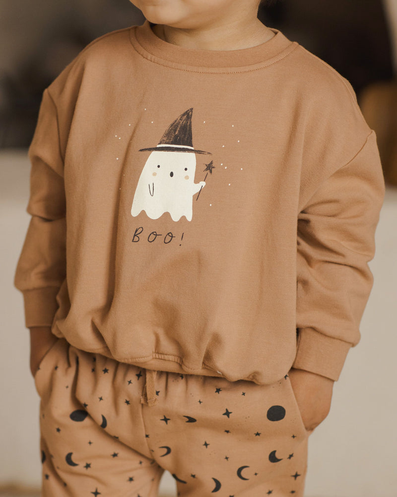 close up of the ghost on the sweatshirt holding the wand. the model has hands in his pockets. 