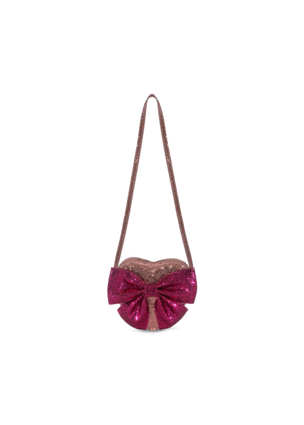 light pink shouder bag with darker pink glitter bow. the bag is a heart shape with a shoulder/crossbody strap. 