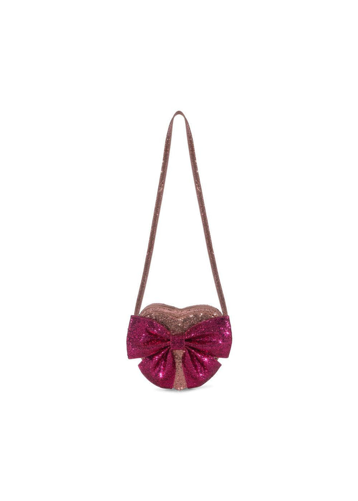 light pink shouder bag with darker pink glitter bow. the bag is a heart shape with a shoulder/crossbody strap. 
