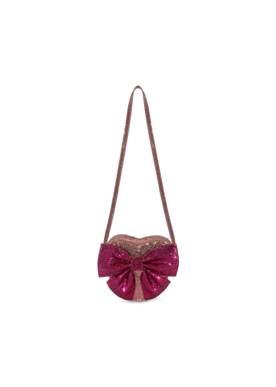 light pink shouder bag with darker pink glitter bow. the bag is a heart shape with a shoulder/crossbody strap. 