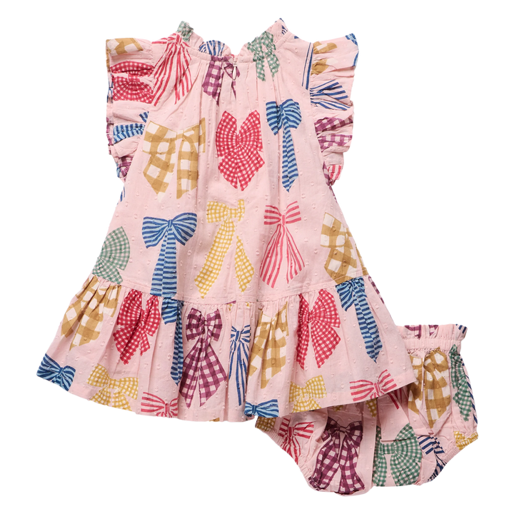 A toddler girl's two-piece outfit set consisting of a sleeveless ruffle-sleeve dress and matching bloomers, both in light pink with a colorful pattern of gingham and solid bow motifs in red, blue, yellow, green, and purple.