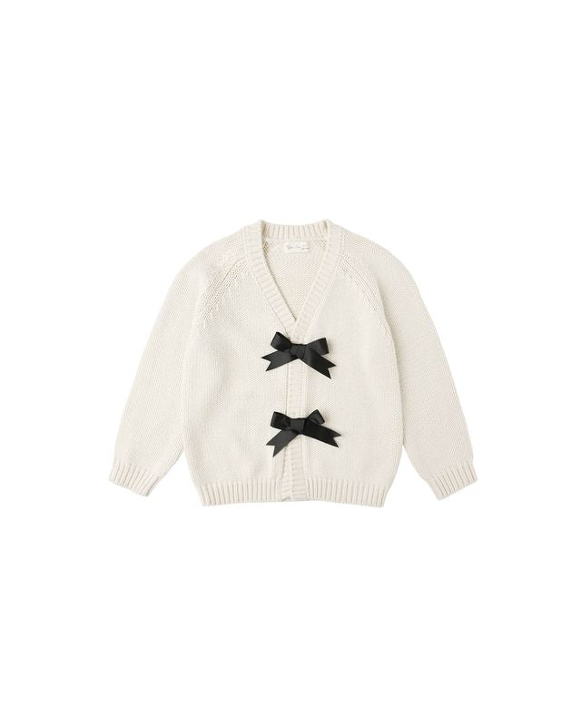 White cardigan with black bows on a white background
