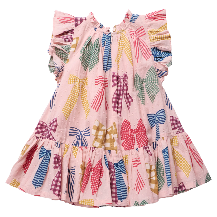 A pink tiered dress for toddlers or girls, featuring a playful all-over print of colorful bow patterns in red, blue, green, yellow, and purple. The dress has ruffled sleeves, a ruffled neckline, and a ruffled hem, shown against a plain white background.