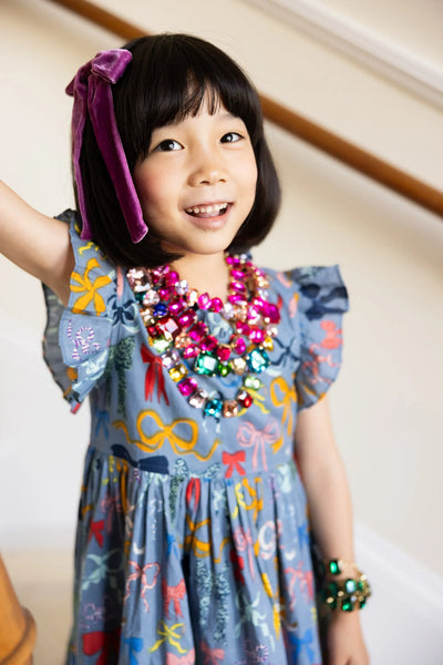 This picture has a little girl modeling the Jennifer dress, it has a roomy fit and he sleeves fan out beautifully! The Little girl has a bunch of necklaces layered on the dress. 