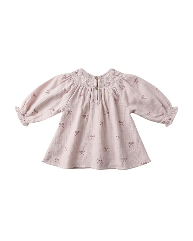 Pink baby dress with bow pattern on a white background