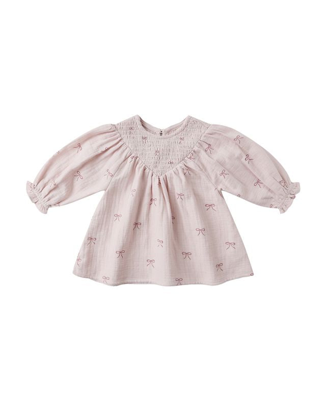 Pink baby dress with bow pattern on a white background