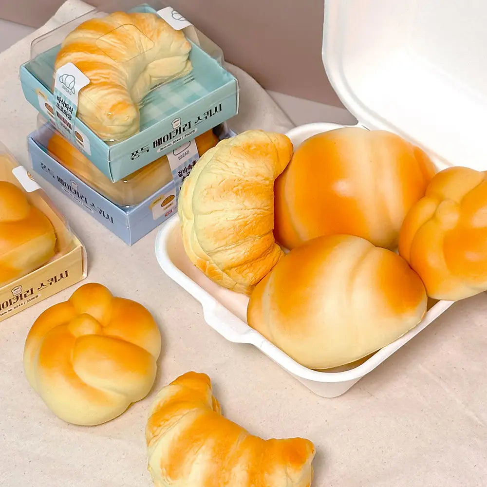 Assorted bread loaves in boxes on a beige surface