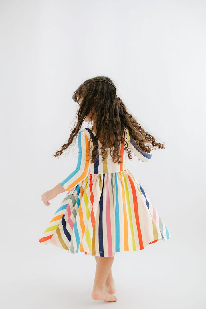 Child wearing a colorful striped dress on a white background