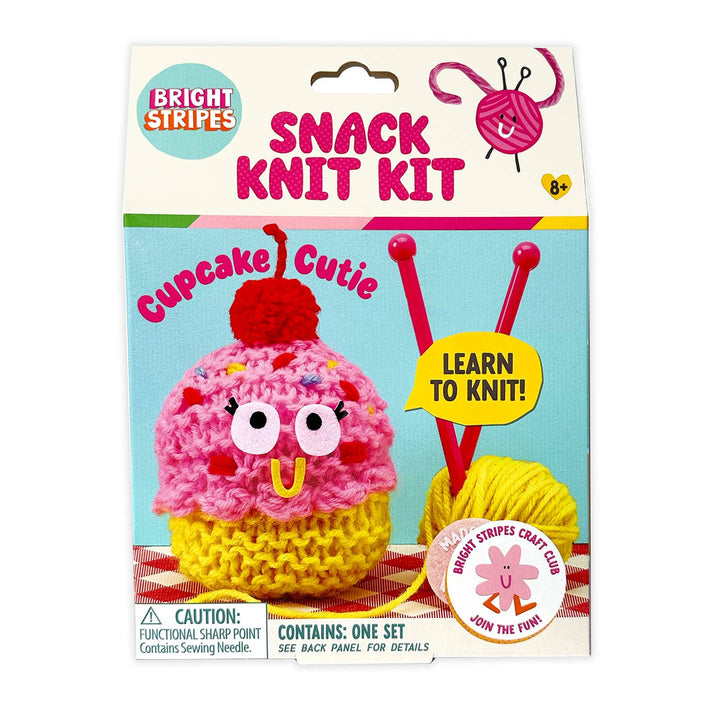 Snack knit kit packaging with a cupcake-themed knitted item and knitting needles on a white background.
