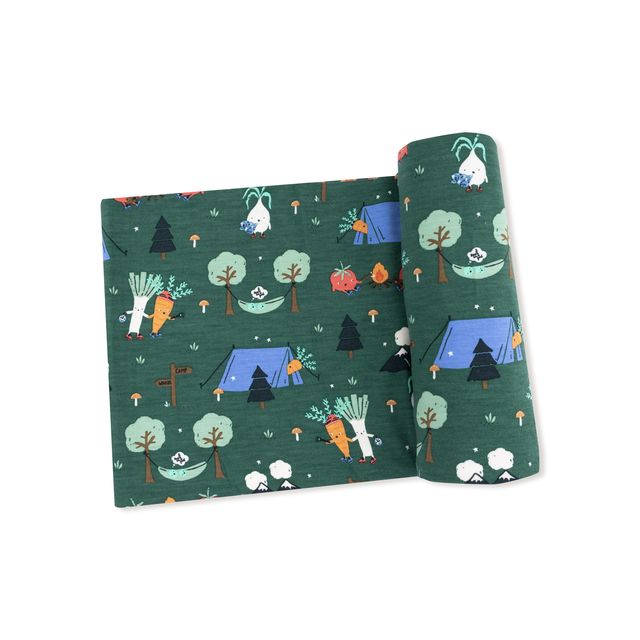 baby swaddle in dark green color with vegetables camping outside 