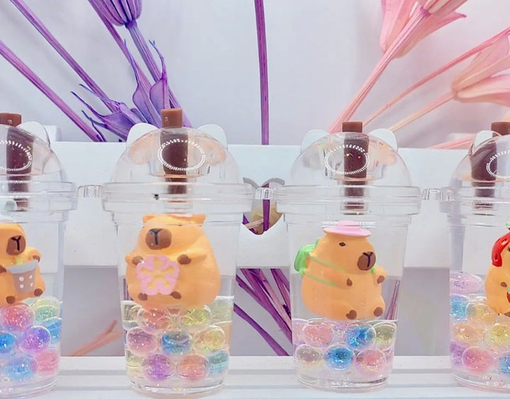 Clear bottles with capybara and boba-shaped stoppers and colorful beads on a keychain