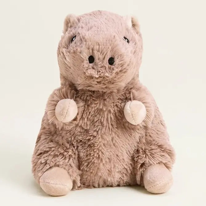A plush stuffed animal pig in a dusty pinkish-brown color, sitting against a solid off-white background.