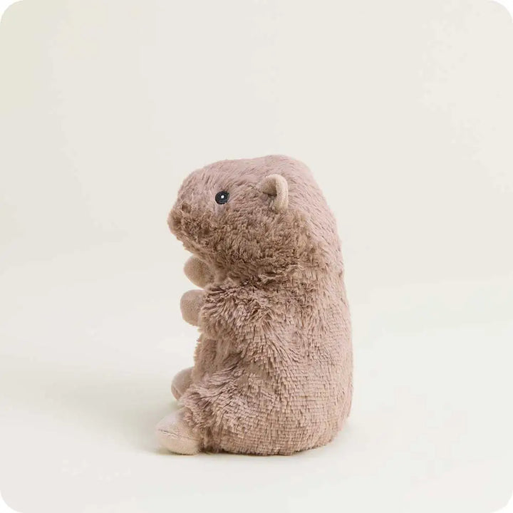 A plush capybara toy in a dusty taupe-brown color, sitting upright on a clean, light off-white background.