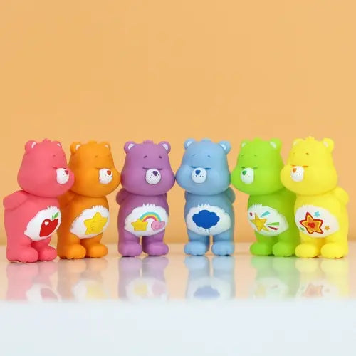 Six colorful cartoon bear figurines with different designs on their bellies against a yellow background.
