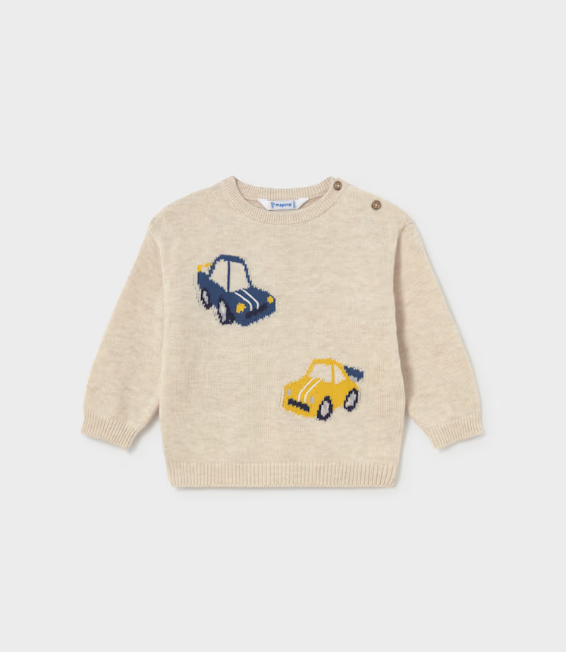 A cream-colored knit baby sweater featuring two knitted car motifs, one blue with white stripes and one yellow, on a light gray background.