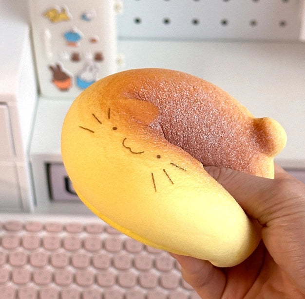 cat bread squishy toy being squeezed by a hand. 