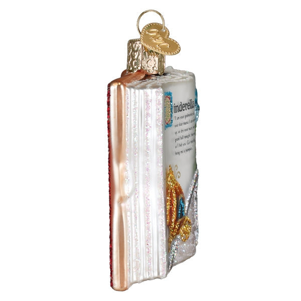 Decorative ornament shaped like an open book with a gold ring on a white background