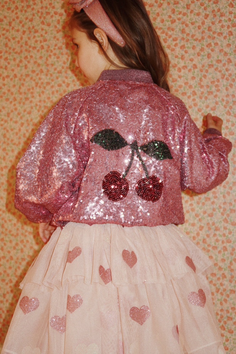 the jacket is being modeled by a young girl. This is the back of the jacket. she is wearing it with the beige ruffled tulle skirt with hearts on it. 