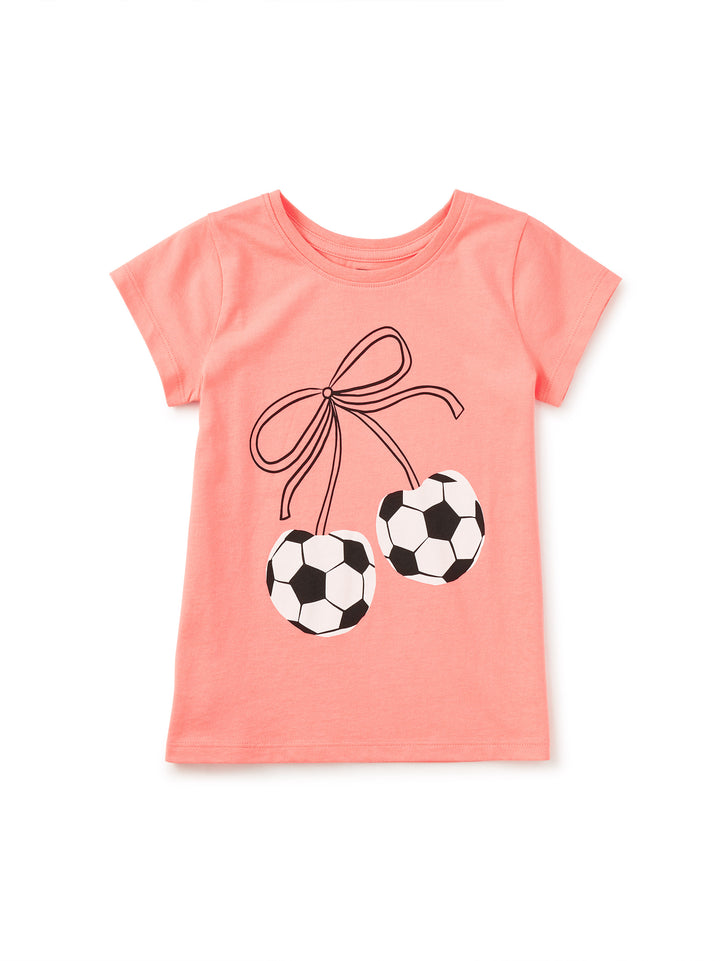 peach tee with soccer cherries tied with a bow