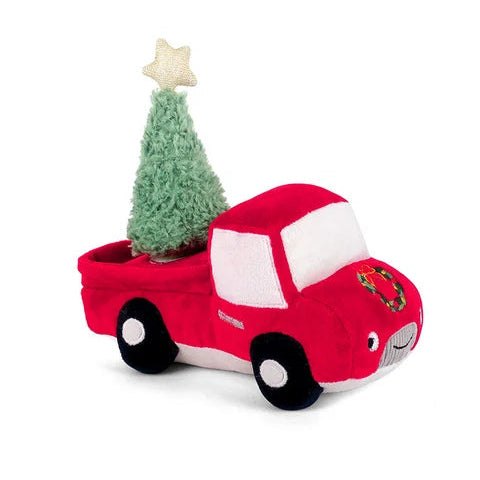 red truck with a christmas tree  in the back of a truck 