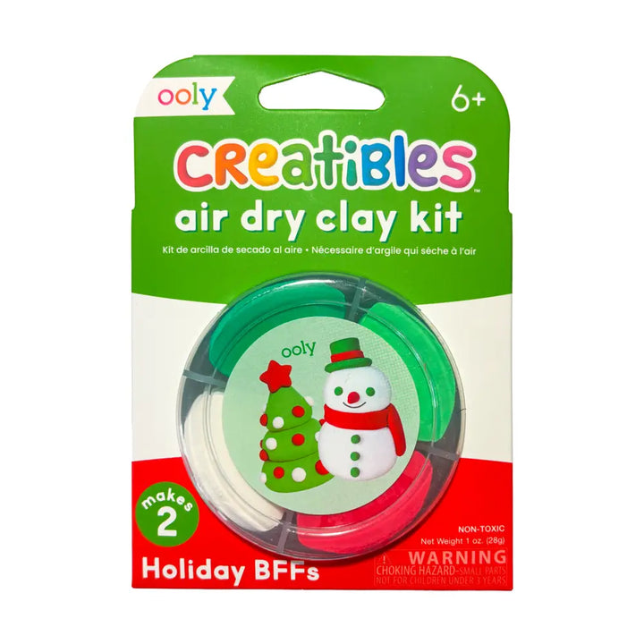 Ooly Creatibles Air Dry Clay Kit in Holiday BFFs colorway, featuring a green, white, and red package with a circular window showing the three clay discs and a snowman/Christmas tree illustration.